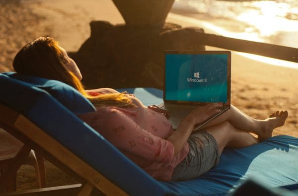 Woman on computer on beach