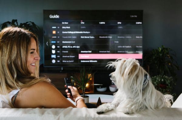 Woman and dog scrolling through channel guide