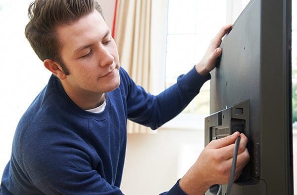 Man plugging in cord to tv