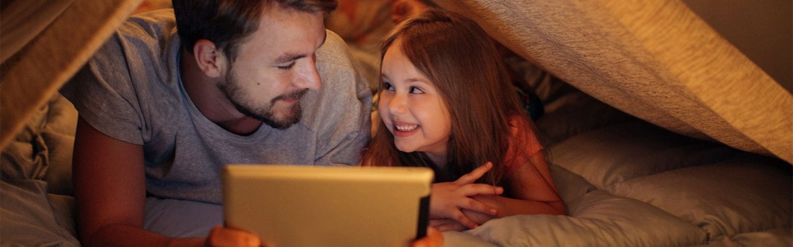 Father and daughter in fort on tablet