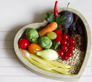heart shaped bowl full of vegatables and legumes