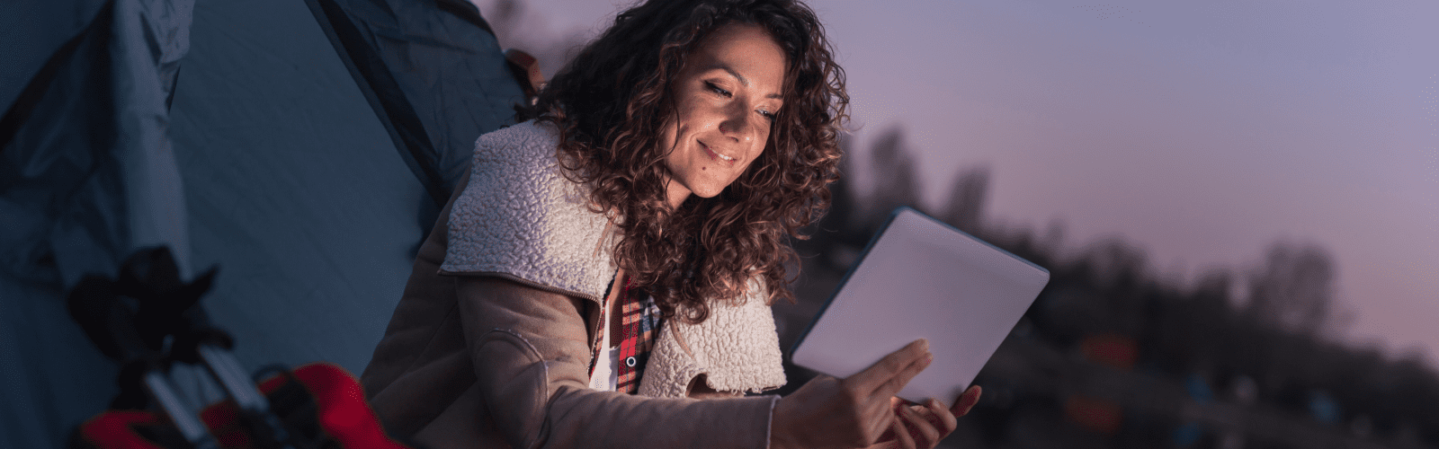 Woman camping with tablet.