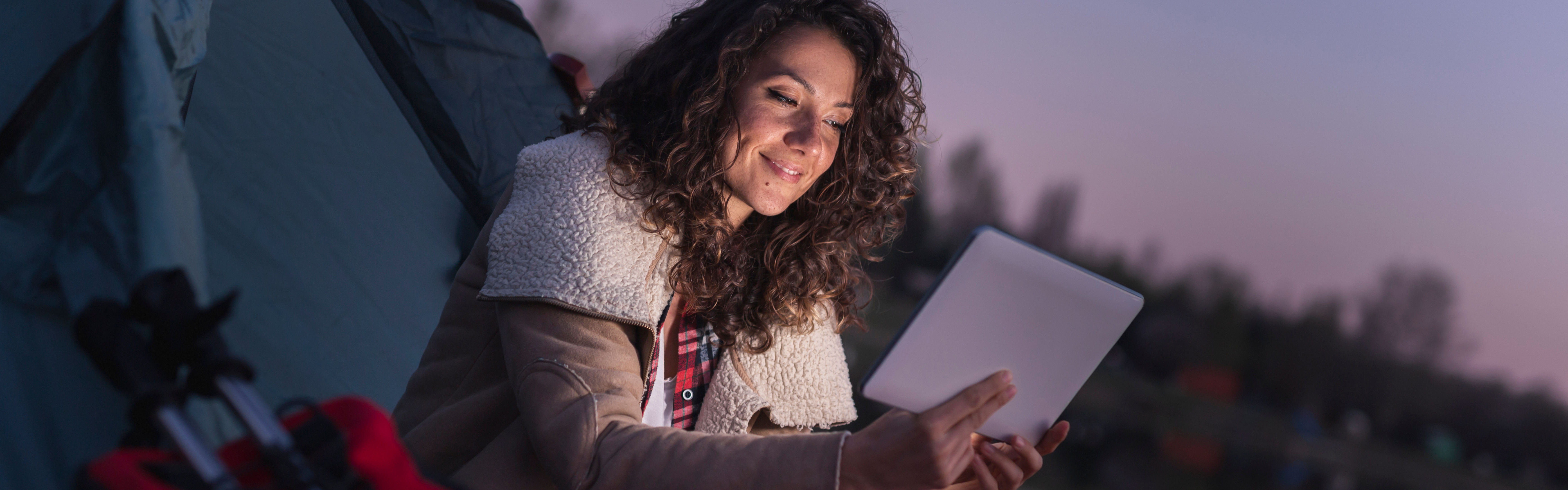 Woman using tablet while camping