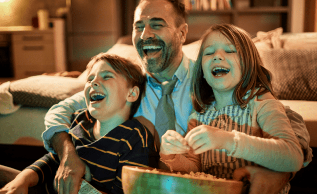 Family laughing eating popcorn.