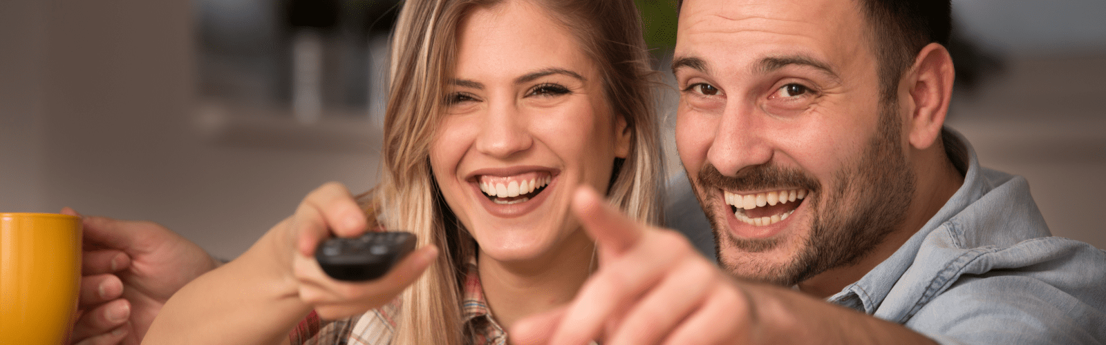 Couple laughing while watching tv