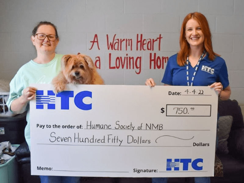 Holding a check with HTC $750 donation to Humane Society of NMB 