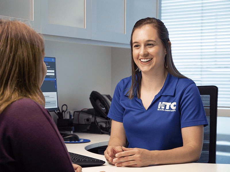 HTC staff at desk with customer.