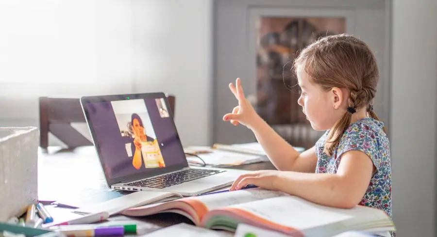 A young girl interacting with teacher in an online, virtual learning session.