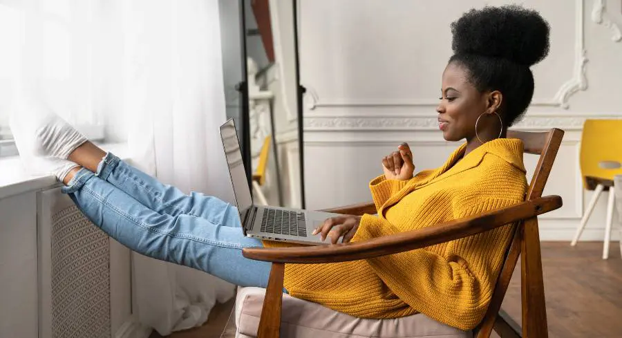 Young adult relaxing while chatting with friends from a laptop computer.