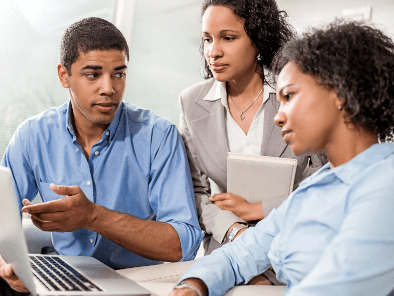 a young tech helping two women understand how to best use their computer
