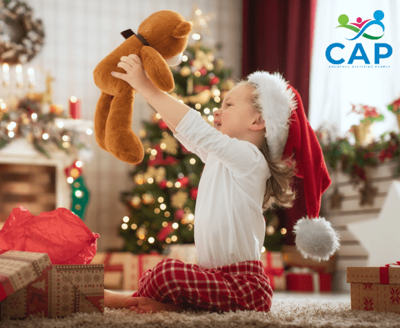 Little kid playing with teddy bear at Christmas