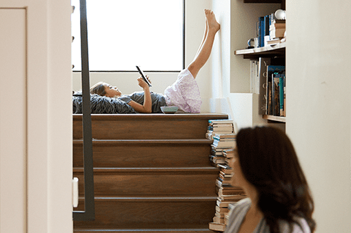 Girl sitting on stairs, watching a tablet