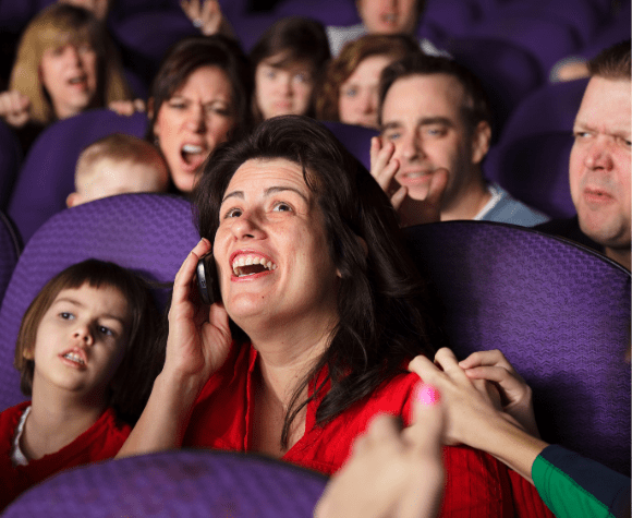Woman using cellphone in movie theater