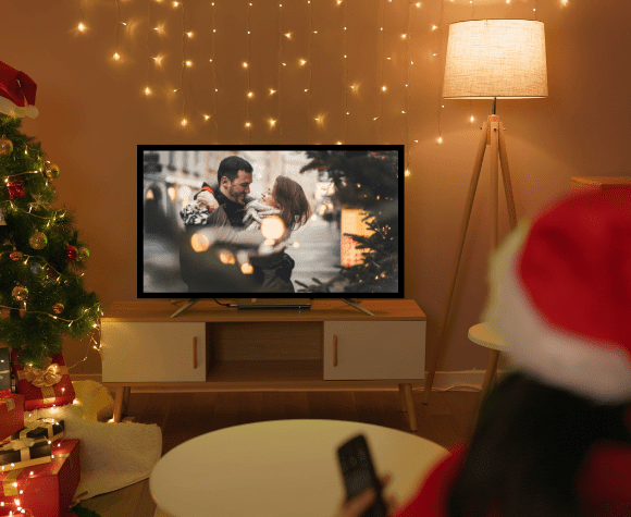 woman sitting on sofa watching christmas movie