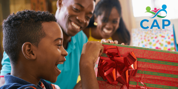 Young boy happily opening Christmas gift