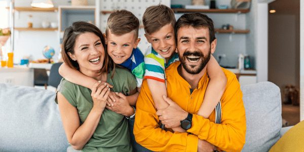 Family smiling and sitting on their couch