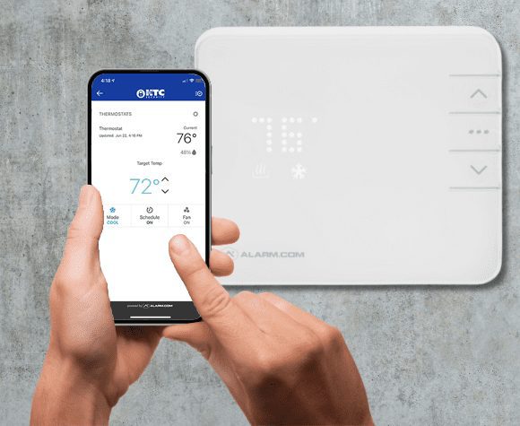 Person managing their smart thermostat with their smartphone