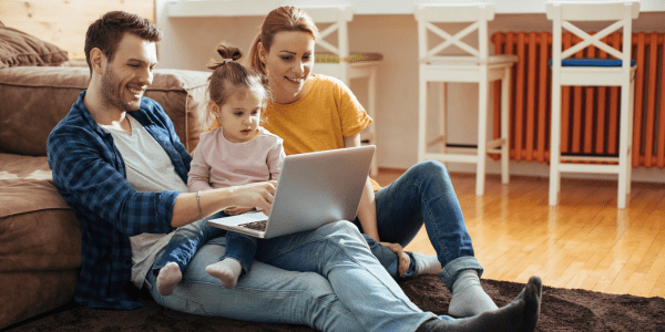 Couple with young child using laptop