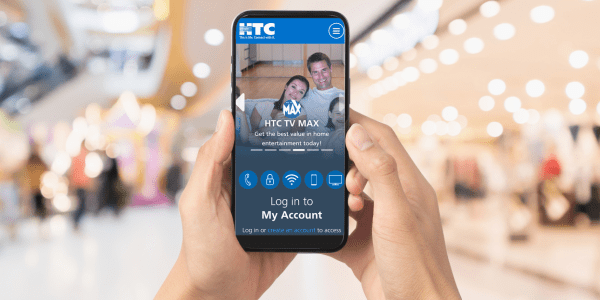 Hands holding a smartphone showing you can log in to your HTC account on the go