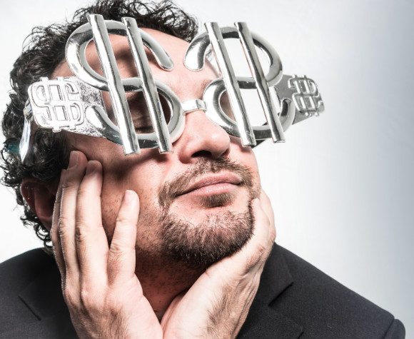 Man wearing glasses in the shape of dollar signs
