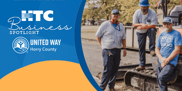3 HTC workers pose next to construction equipment; HTC Business Spotlight and United Way of Horry County logos appear at left