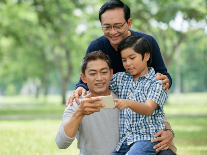 3 men looking at content on a mobile device.