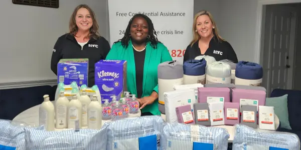 Volunteers with the Pee Dee Coalition stand behind a collection of donated household items.