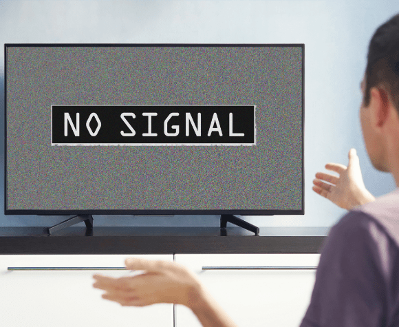 man looking at TV with NO signal displayed