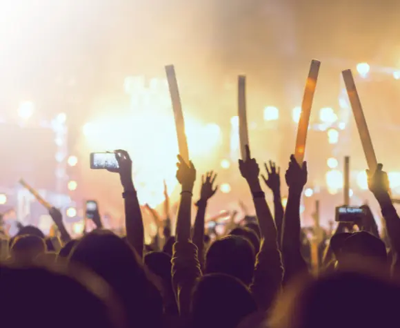 crowd waving arms at a concert event