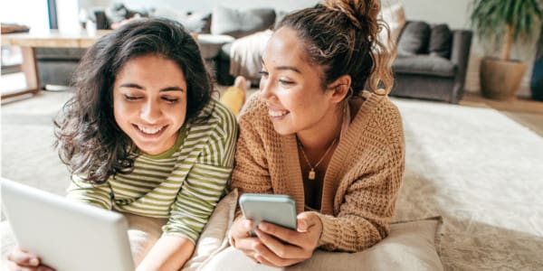 2 women on tablet and cellphone