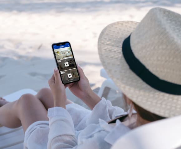 woman checking on home while on vacation at the beach