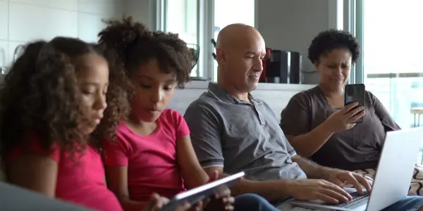 family using internet on tablet, laptop and cellphone
