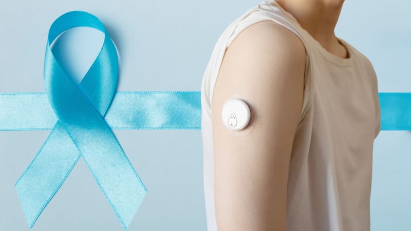 blue ribbon for diabetes awareness and arm with glucose monitor