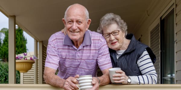 senior couple on front porch with coffee