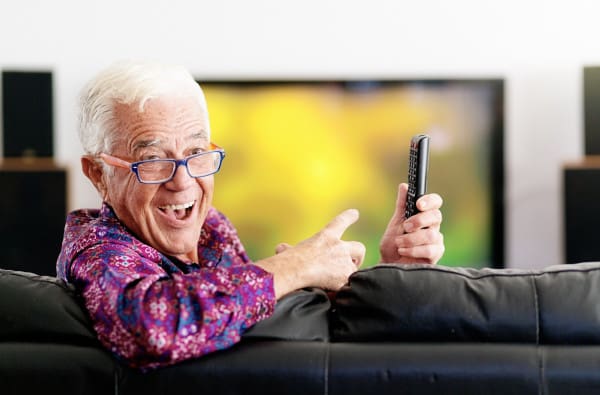 senior man pointing to tv remote