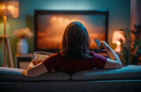woman watching tv on a sofa